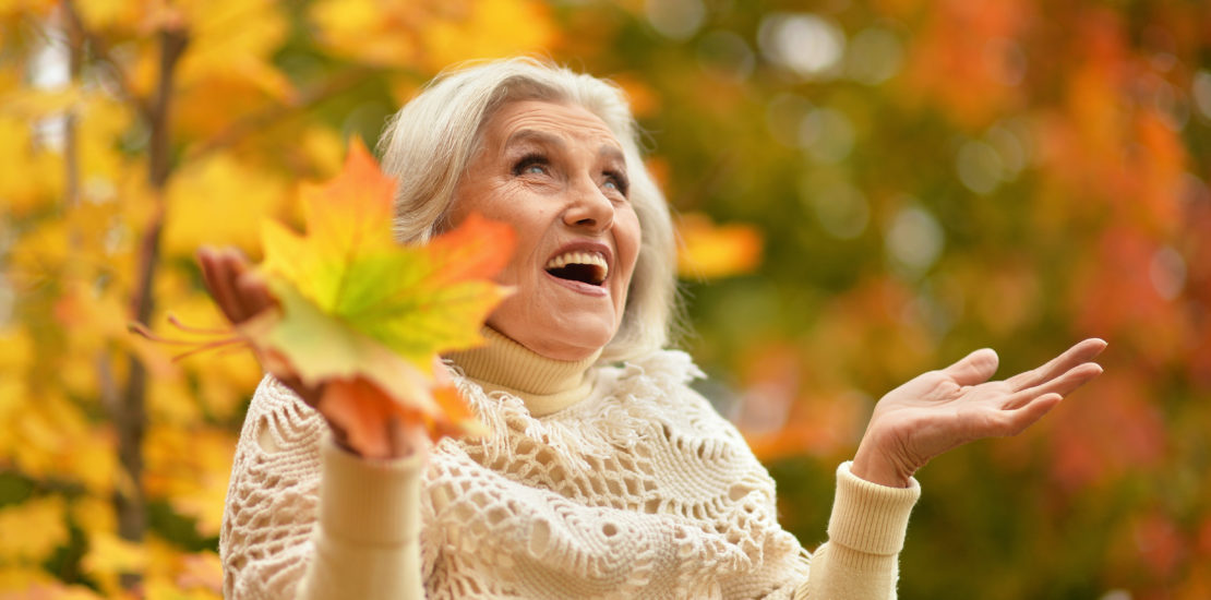 Portrait of happy senior beautiful woman in autumn park