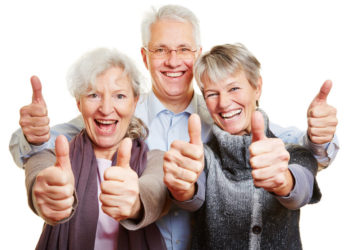 Three happy senior people holding their thumbs up