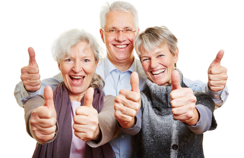 Three happy senior people holding their thumbs up